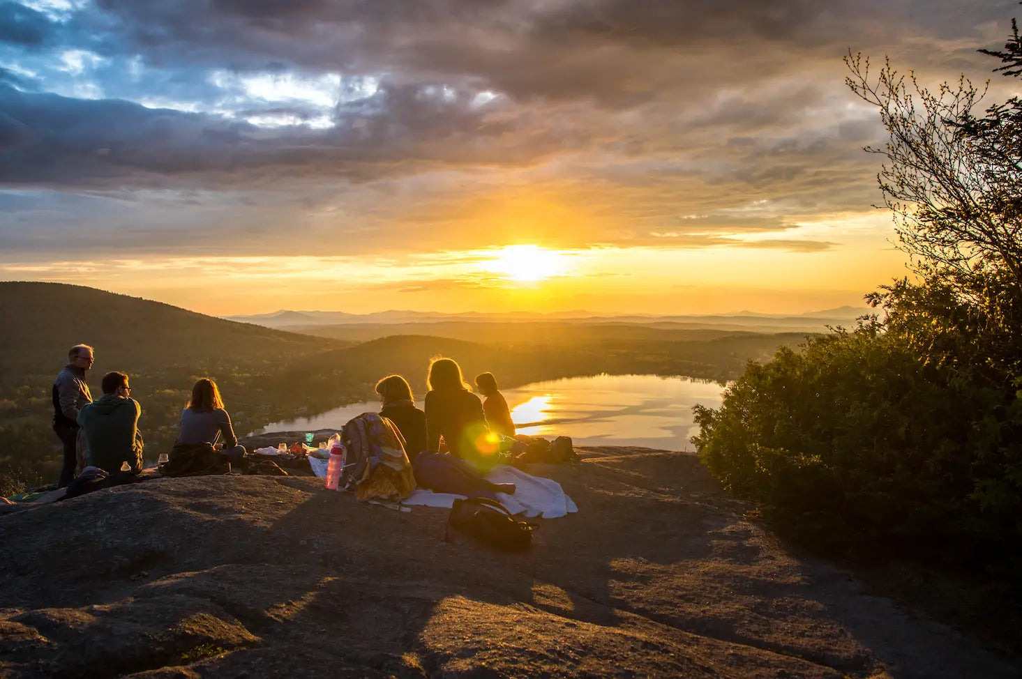 Group of happy hikers enjoying a beautiful sunset